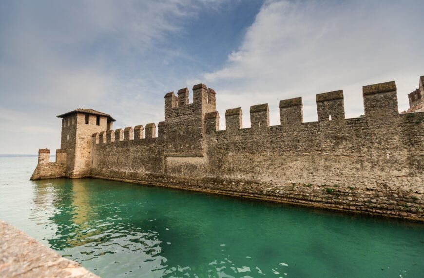 brown concrete building near body of water under blue sky during daytime; high switching costs as an economic moat