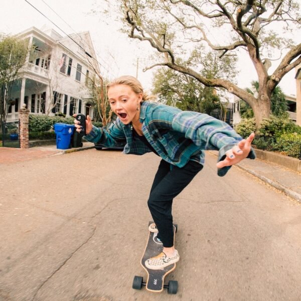 a woman riding a skateboard down a street