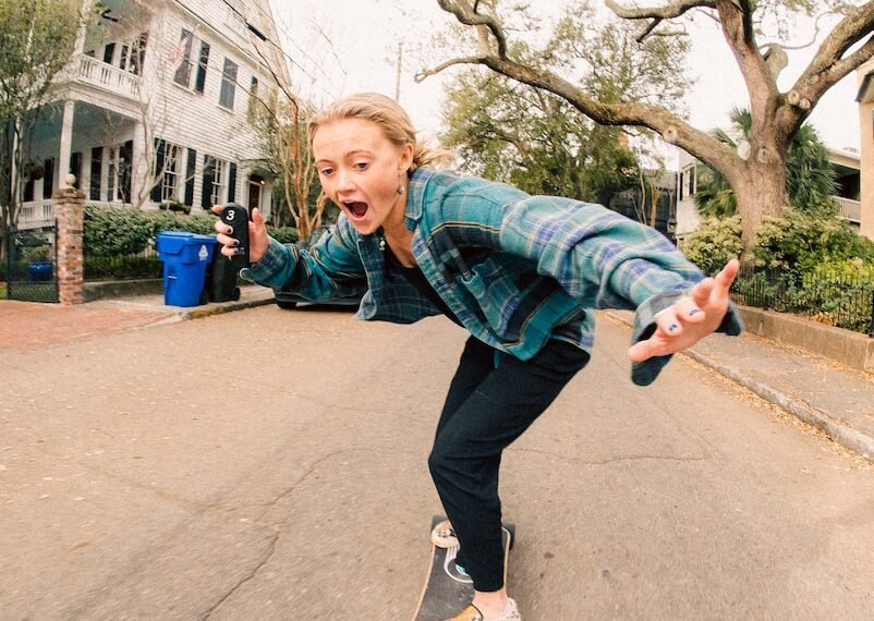 a woman riding a skateboard down a street